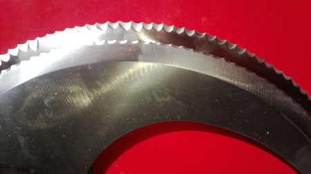 before and after (underneath) image overlaid of face side of medium pair of industrial serrated robo blades for a machine used fundamentally for chick pea blending